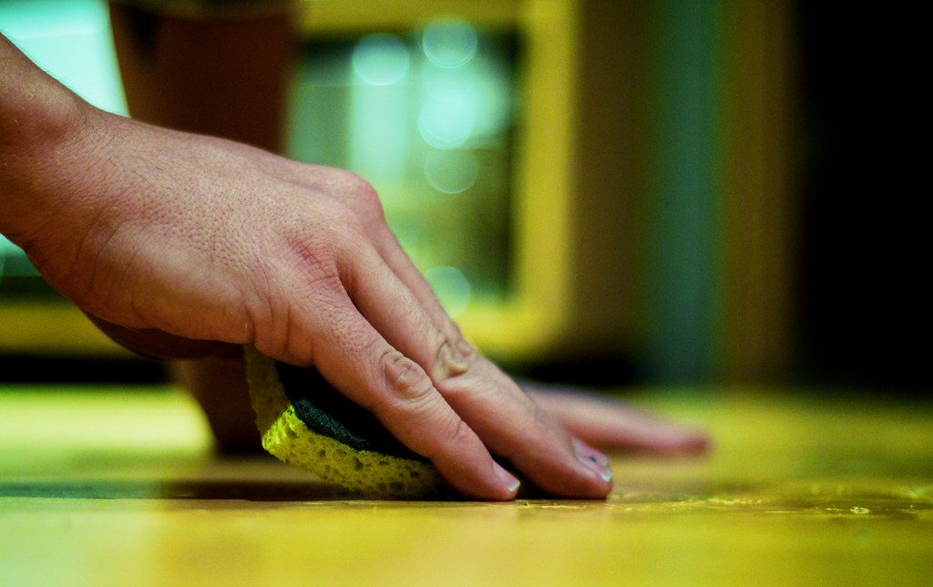 A surface being cleaned with soap and sponge
